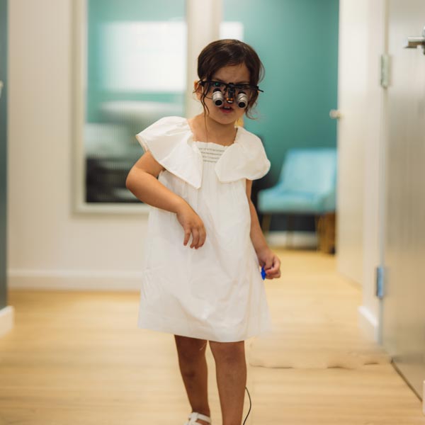 little girl wearing magnifying goggles